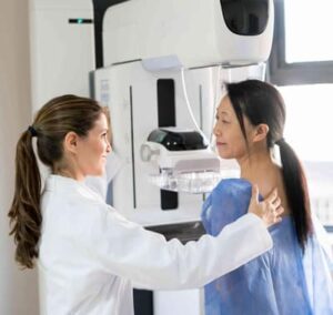 Doctor assisting a woman during a mammogram